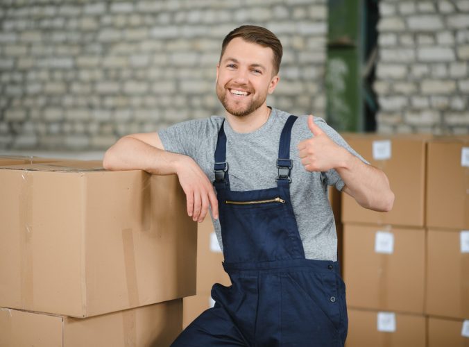 Warehouse worker carrying a carton for delivery to production stock